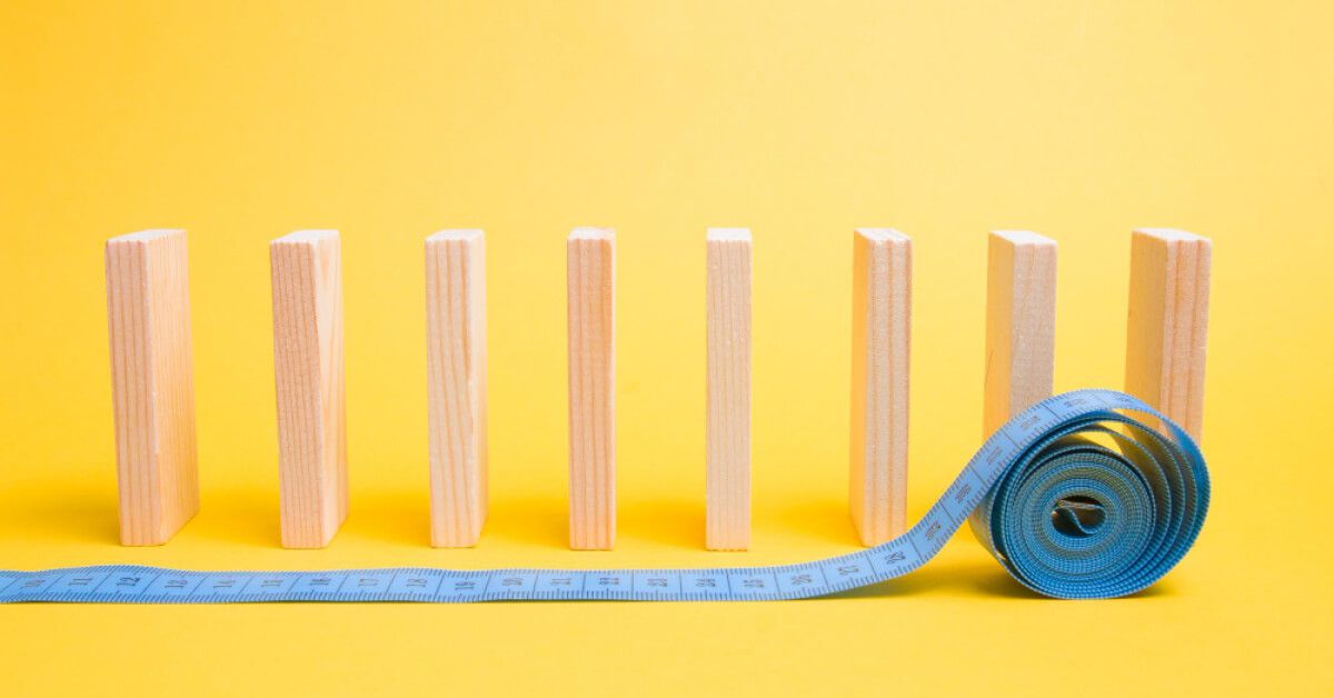 A blue measuring tape in front of a series of wooden blocks