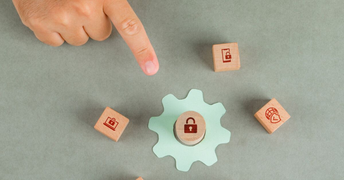 Person pointing at a wooden chip with a lock icon