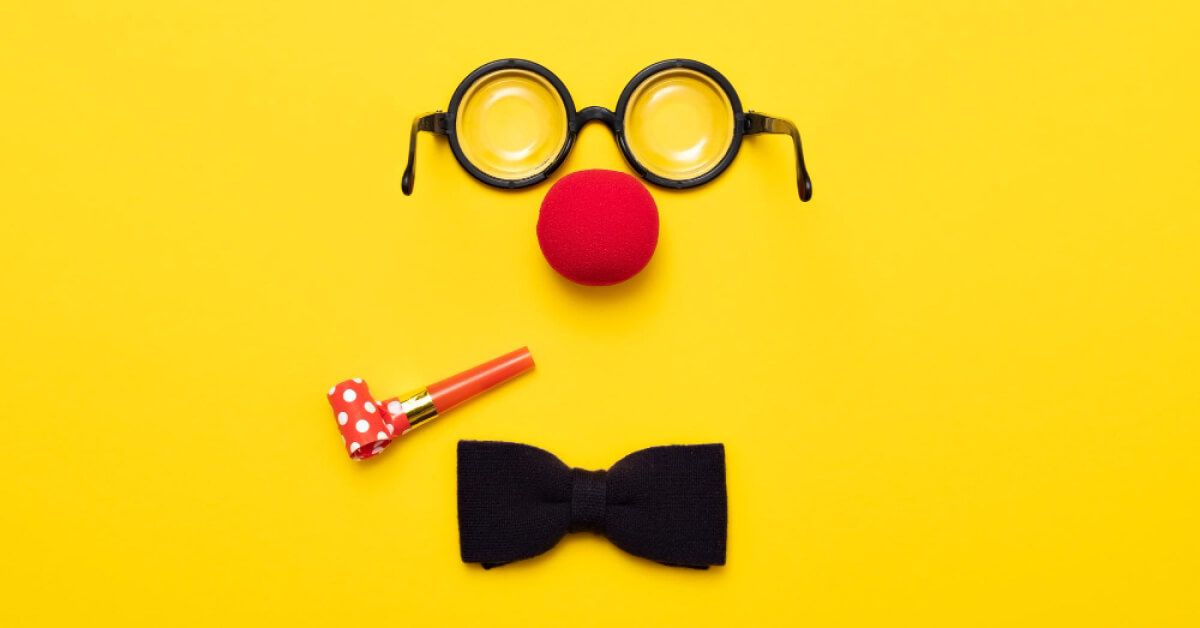 Bowtie and clown accessories against a yellow backdrop