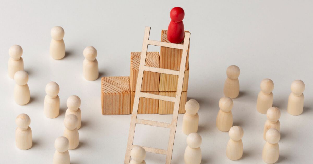 Red pawn on top of a tower of blocks with a ladder, amidst other white pawns