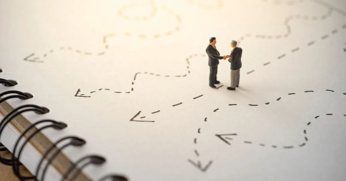 Miniature businessmen figurines over a notepad